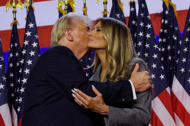 Calon presiden dari Partai Republik Donald Trump memeluk istrinya Melania saat menyampaikan pidato kemenangan Pemilu AS 2024 di Palm Beach County Convention Center, West Palm Beach, Florida, AS, Rabu (6/11/2024). Foto: Brian Snyder/REUTERS