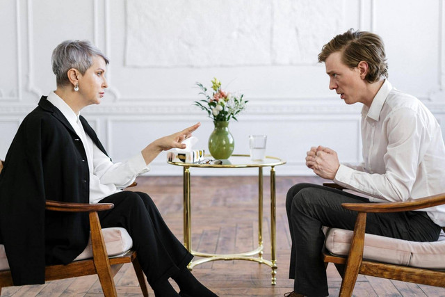 Foto oleh cottonbro studio dari Pexels: https://www.pexels.com/id-id/foto/man-in-white-dress-shirt-and-black-pants-sitting-on-brown-wooden-chair-4098367/