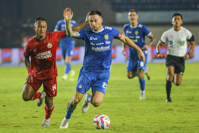 Pesepak bola Persib Bandung Marc Klok (tengah) berebut bola dengan pesepak bola Semen Padang FC Dimas Roni Saputra (kiri) pada pertandingan BRI Liga 1 di Stadion Si Jalak Harupat, Kabupaten Bandung, Jawa Barat, Jumat (1/11/2024). Foto: Raisan Al Farisi/ANTARA FOTO