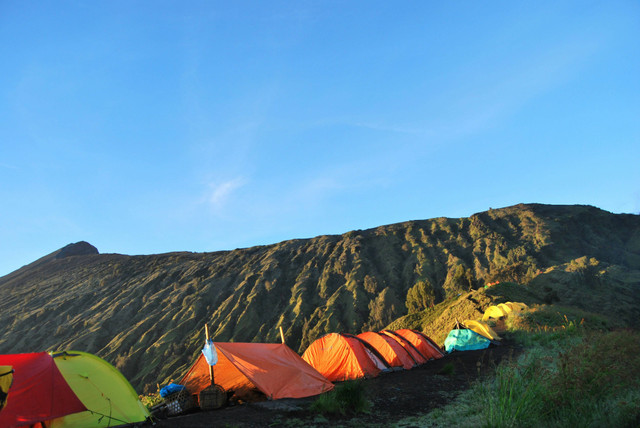 Perkiraan Biaya Naik Gunung Rinjani. Pendaki berkemah di Gunung Rinjani. Sumber: Unsplash/Monteverdo Barnsley.