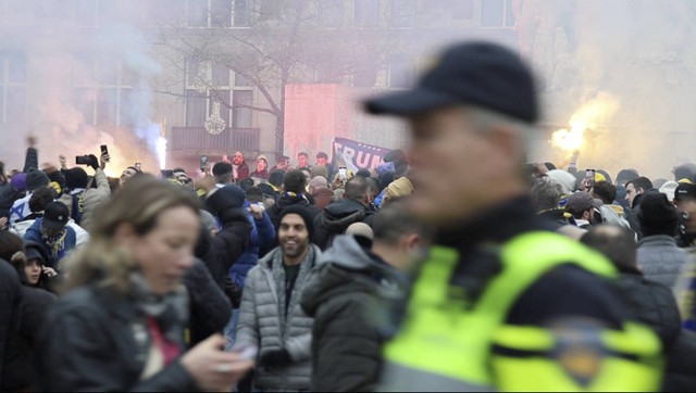 Pendukung Maccabi Tel Aviv dari Israel berdemonstrasi dan menyalakan suar saat seorang polisi berpatroli di daerah tersebut di Amsterdam, Belanda, 7 November 2024. Foto: Michel Van Bergen/via REUTERS