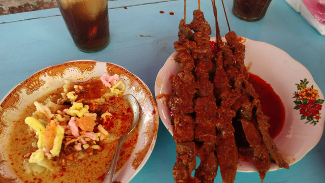 Menikmati sate blengong dengan kupat yang disiram kuah kuning.