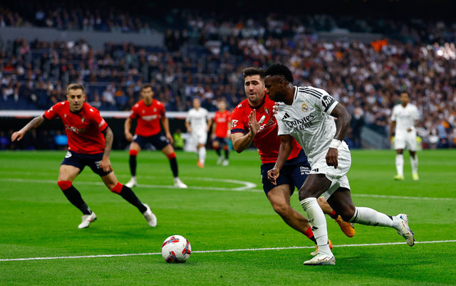 Vinicius Junior dari Real Madrid beraksi bersama Jesus Areso dari Osasuna pada pertandingan LaLiga antara Real Madrid melawan Osasuna di Santiago Bernabeu, Madrid, Spanyol - 9 November 2024. Foto: Susana Vera/REUTERS 