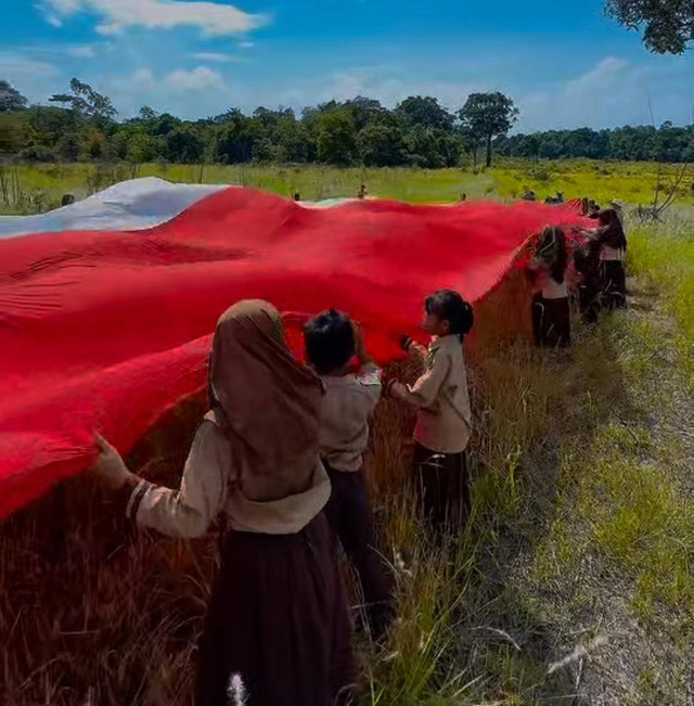 Siswa Pulau Karimata membentangkan bendera Merah Putih di hari Pahlawan. Foto: Dok, Instagram @rita_bersamakalian