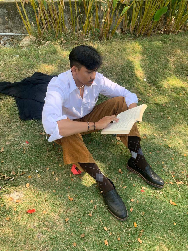 author sedang membaca buku di taman