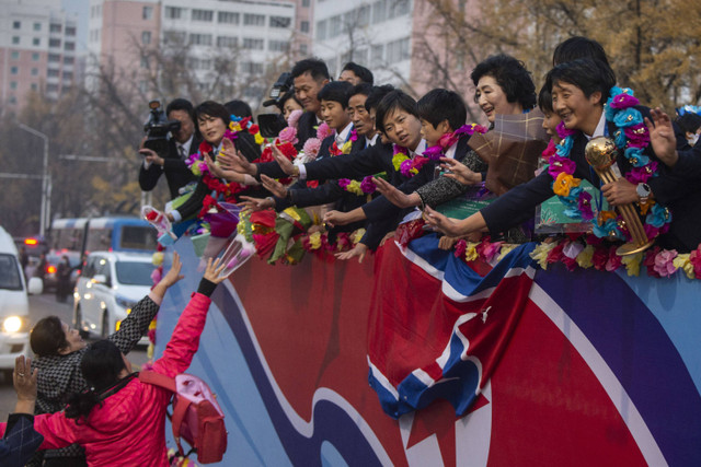 Orang-orang menyambut anggota tim sepak bola wanita U-17 Korea Utara di sebuah jalan di Pyongyang, Korea Utara (9/11/2024). Foto: Kim Won Jin/AFP