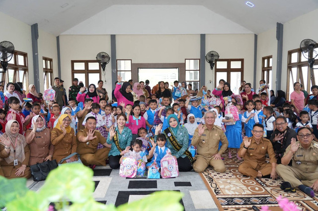 Ayah dan Bunda PAUD Kalbar, Harisson dan Windy Prihastari saat membagikan alat tulis untuk anak-anak di perbatasan. Foto: Dok. Adpim Pemprov Kalbar