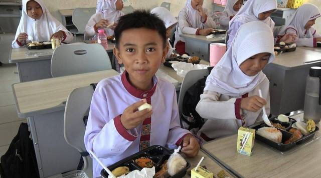 Salah satu siswa di SDN 145 Palembang sedang menikmati makan siang gratis dan bergizi, Foto : Abdullah Toriq/Urban Id