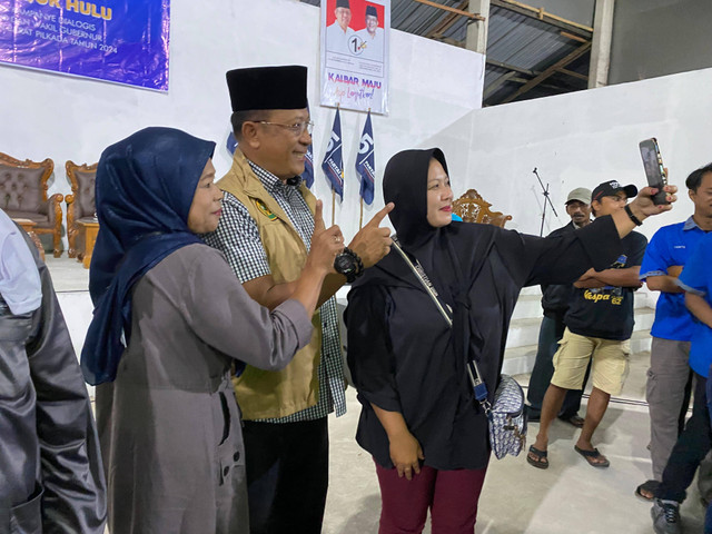 Warga Desa Wajok Hulu saat mengajak Didi Haryono berfoto bersama. Foto; Yulia Ramadhiyanti/Hi!Pontianak