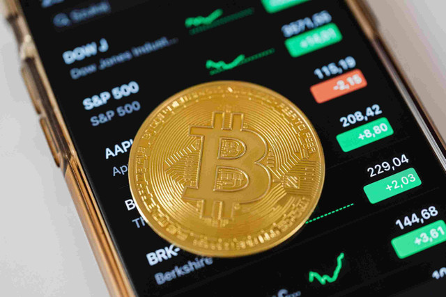 Pengaruh Bitcoin terhadap Masyarakat Islam: Menurut Perspektif Ekonomi Syariah   https://www.pexels.com/photo/gold-round-coin-on-top-of-a-cellphone-5980856/