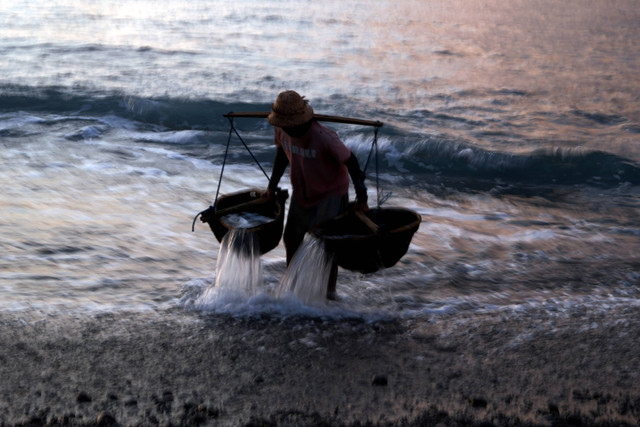 Petani mencari air laut saat proses pembuatan garam di Pantai Kusamba, Klungkung, Bali. Foto: Nyoman Hendra Wibowo/ANTARA FOTO