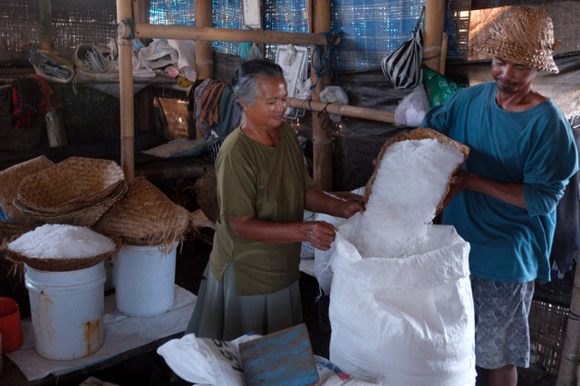 Petani mengumpulkan garam ke dalam karung untuk dijual di Pantai Kusamba, Klungkung, Bali. Foto: Nyoman Hendra Wibowo/ANTARA FOTO