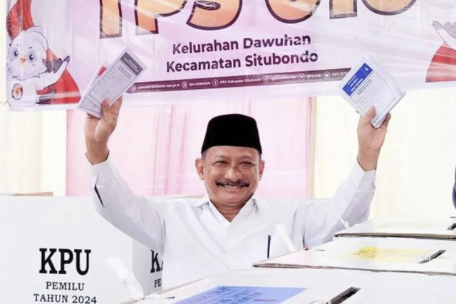 Bupati Situbondo Karna Suswandi menunjukkan surat suara sebelum memasukkan ke dalam kotak suara di TPS 16 Kelurahan Dawuhan, Kecamatan Situbondo, Kabupaten Situbondo, Rabu (14/2/2024).  Foto: Novi Husdinariyanto/Antara