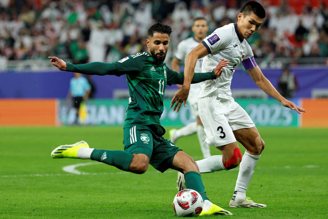 Pemain Timnas Arab Saudi Saleh al-Shehri berusaha melewati pemain Timnas Kirgistan Tamirlan Kozubaev pada pertandingan Grup F Piala Asia 2024 di Stadion Ahmad Bin Ali, Al-Rayyan, Qatar pada 21 Januari 2024. Foto: Karim Jaafar / AFP