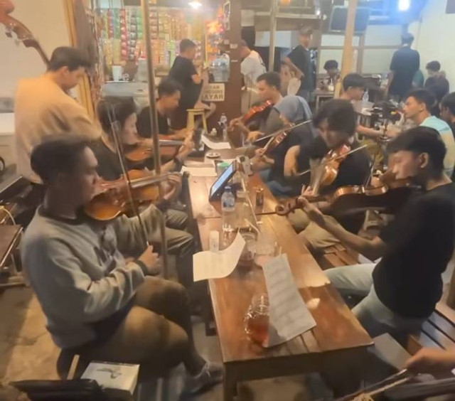 Tangkapan layar sekelompok anak muda di Surabaya main orkestra di warkop.