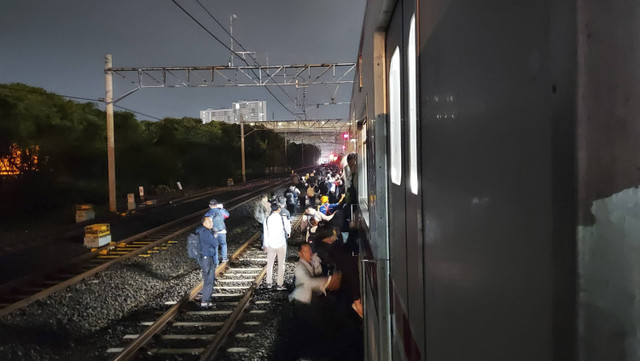 Penumpang KRL keluar dari gerbong saat kereta yang ditumpanginya mengalami gangguan di antara St Kraji-Bekasi, Selasa (19/11/2024). Foto: kumparan