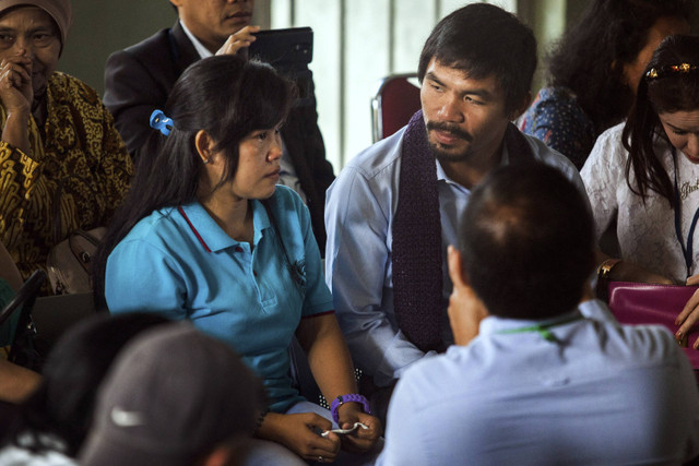 Superstar tinju Filipina, Manny Pacquiao (kanan) mendengarkan Mary Jane Veloso (kiri), seorang terpidana mati asal Filipina, dalam kunjungannya ke Penjara Wirogunan, Yogyakarta, pada tanggal 10 Juli 2015. Foto: Suryo Wibowo/AFP