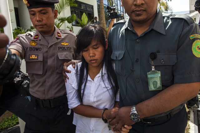 Terpidana penyelundup narkoba asal Filipina yang dijatuhi hukuman mati, Mary Jane Fiesta Veloso, dikawal oleh polisi Indonesia saat tiba di pengadilan di Sleman, Jawa Tengah, untuk menjalani sidang peninjauan kembali pada tanggal 3 Maret 2015.  Foto: Suryo Wibowo/AFP