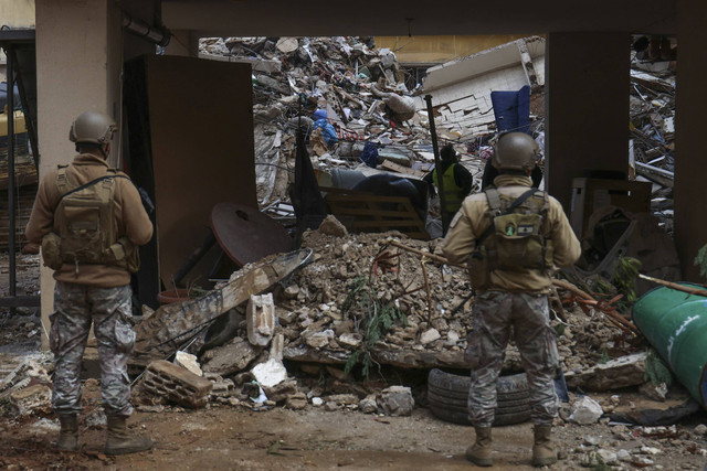 Tim penyelamat membersihkan puing-puing di lokasi serangan udara Israel yang menargetkan kawasan al-Shiyah di pinggiran selatan Beirut, Selasa (19/11/2024). Foto: Anwar Amro/AFP