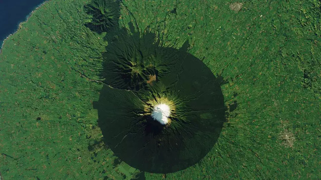 Lereng Gunung Taranaki di Selandia Baru dikelilingi oleh Taman Nasional Egmont, yang terdiri dari lingkaran pepohonan nyaris sempurna, termasuk batang-batang pohon yang melengkung menyerupai goblin. Foto: NASA/Landsat 8