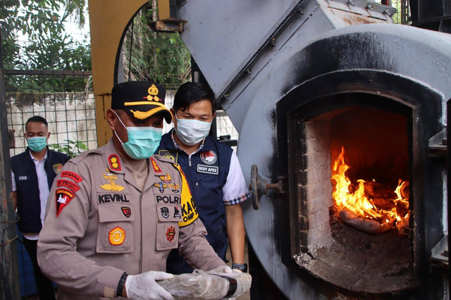 Kapolres OKU Timur Kevin Leleury saat membakar ganja. Foto : Dok. Polres OKU Timur