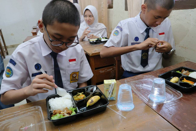 Siswi SMP di Palembang saat menikmati makan bergizi gratis. Foto : Dok Kominfo Palembang