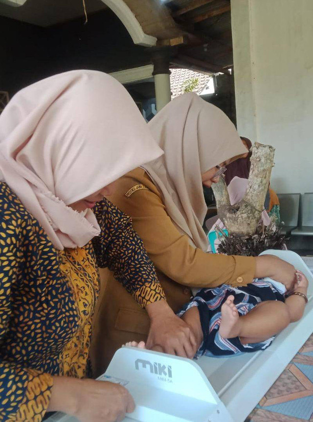 Dokumentasi Pribadi Bidan Citra Saat Melakukan Pemeriksaan Bayi di Posyandu Wahyu Dusun Karangharjo Desa Temuasri Kecamatan Sempu Kabupaten Banyuwangi, Jawa Timur. (26/10)