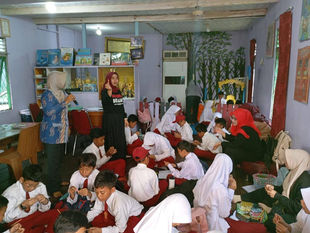 Sulviawati (berdiri kiri) memberikan edukasi kepada pelajar, tentang pemanfaatan barang bekas menjadi kerajinan tangan yang bermanfaat dan bernilai jual. Foto: Dok. PLN Kalbar