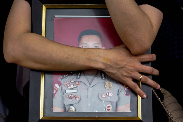 Keluarga membawa foto mendiang Kompol Anumerta Ryanto Ulil Anshar sebelum prosesi pemakaman di Taman Makam Siri Na Passe, Makassar, Sulawesi Selatan, Minggu (24/11/2024). Foto: Hasrul Said/ANTARA FOTO