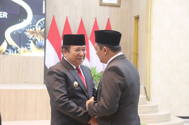 Bupati Jember Hendy Siswanto berjabatan tangan dengan eks Pjs Bupati Imam Hidayat. Foto: Dok. Istimewa