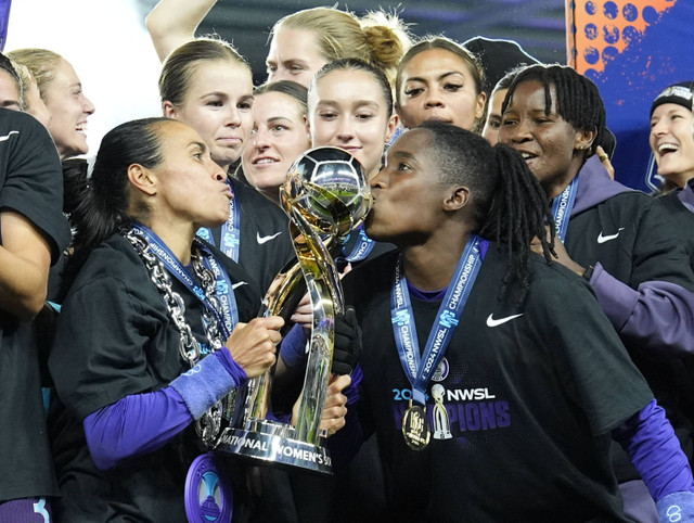 Penyerang Orlando Pride, Marta (10) dan penyerang Orlando Pride, Barbra Banda (22) mencium trofi kejuaraan setelah mengalahkan Washington Spirit pada pertandingan Kejuaraan NWSL 2024 di Stadion CPKC, Sabtu (23/11/2024). Foto: Jay Biggerstaff/USA TODAY Sports via REUTERS