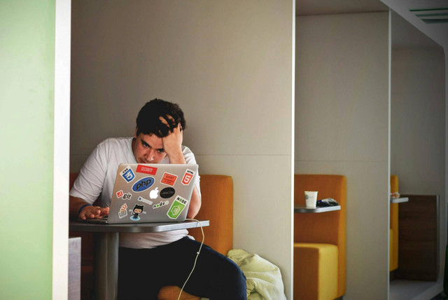 Ilustri pria sedang stres (Photo by Tim Gouw: https://www.pexels.com/photo/man-in-white-shirt-using-macbook-pro-52608/)