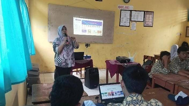 Rida Marlenie saat mengajarkan siswa menggunakan Canva di kelas. Foto: Dok. Pribadi