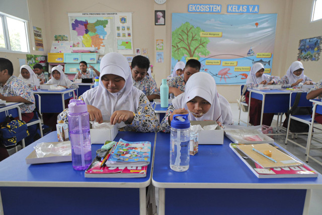 Sejumlah siswa menyantap makanan saat simulasi program Makan Siang Bergizi Gratis di sekolah wilayah Lanud Halim Perdanakusuma di SDS Angkasa 5 Lanud Halim Perdanakusuma, Jakarta, Selasa (26/11/2024). Foto: Iqbal Firdaus/kumparan