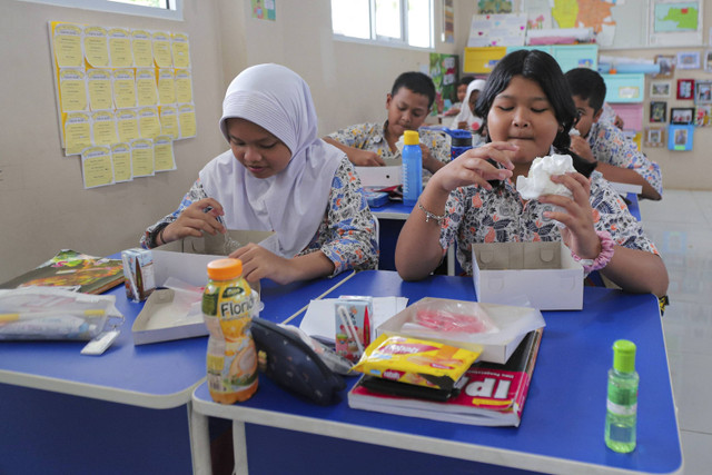 Sejumlah siswa menyantap makanan saat simulasi program Makan Siang Bergizi Gratis di sekolah wilayah Lanud Halim Perdanakusuma di SDS Angkasa 5 Lanud Halim Perdanakusuma, Jakarta, Selasa (26/11/2024). Foto: Iqbal Firdaus/kumparan