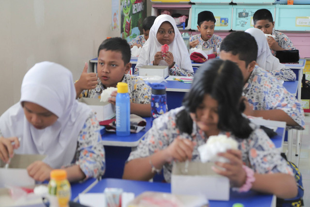 Sejumlah siswa menyantap makanan saat simulasi program Makan Siang Bergizi Gratis di sekolah wilayah Lanud Halim Perdanakusuma di SDS Angkasa 5 Lanud Halim Perdanakusuma, Jakarta, Selasa (26/11/2024). Foto: Iqbal Firdaus/kumparan