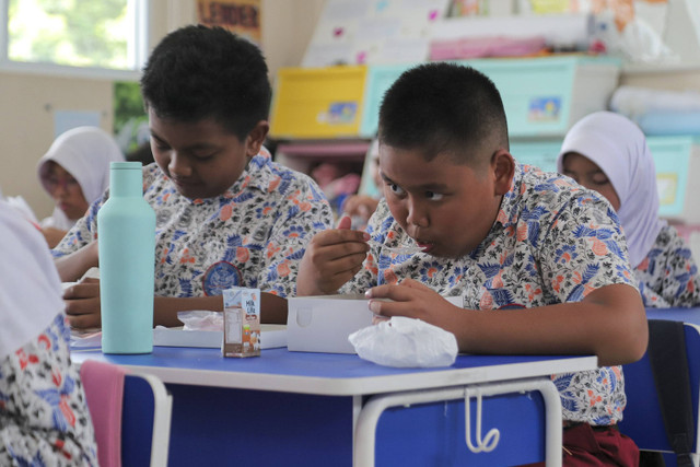 Sejumlah siswa menyantap makanan saat simulasi program Makan Siang Bergizi Gratis di sekolah wilayah Lanud Halim Perdanakusuma di SDS Angkasa 5 Lanud Halim Perdanakusuma, Jakarta, Selasa (26/11/2024). Foto: Iqbal Firdaus/kumparan