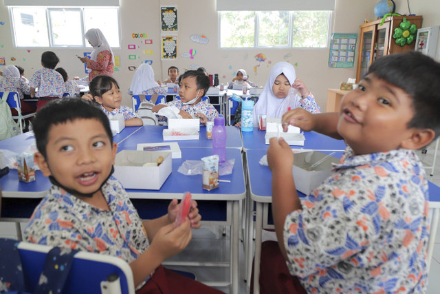 Sejumlah siswa menyantap makanan saat simulasi program Makan Siang Bergizi Gratis di sekolah wilayah Lanud Halim Perdanakusuma di SDS Angkasa 5 Lanud Halim Perdanakusuma, Jakarta, Selasa (26/11/2024). Foto: Iqbal Firdaus/kumparan