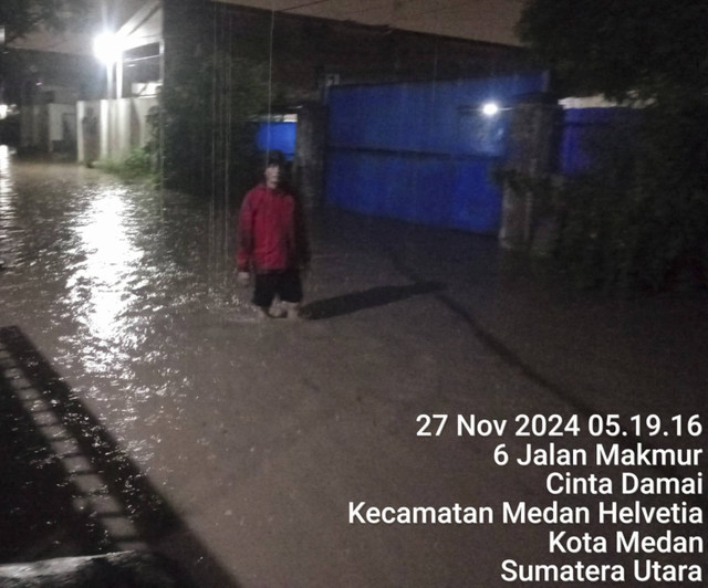 Warga melintas saat banjir pada hari pemilihan kepala daerah serentak di Kota Medan, Rabu (27/11/2024). Foto: Dok. BPBD Medan