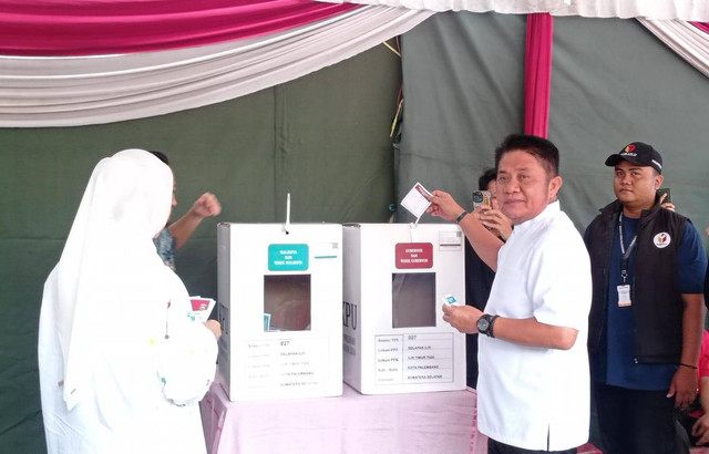 Calon Gubernur Sumsel Herman Deru bersama istri saat memasukan surat suara di kota suara. Foto : Abdullah Toriq/Urban Id