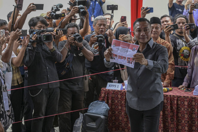 Calon Gubernur DKI Jakarta nomor urut 2 Dharma Pongrekun (kanan) menunjukkan kertas suara sebelum menggunakan hak pilihnya dalam Pemilihan Kepala Daerah (Pilkada) serentak di TPS 31 Lebak Bulus, Jakarta Selatan, Rabu (27/11/2024). Foto: Fauzan/ANTARA FOTO