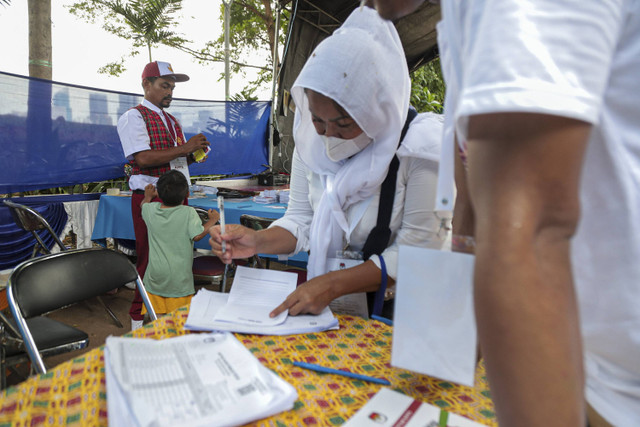 Anggota Kelompok Penyelenggara Pemungutan Suara (KPPS) berbusana seragam sekolah mempersiapkan TPS 005, Petamburan, Tanah Abang, Jakarta, Rabu (27/11/2024). Foto: Iqbal Firdaus/kumparan