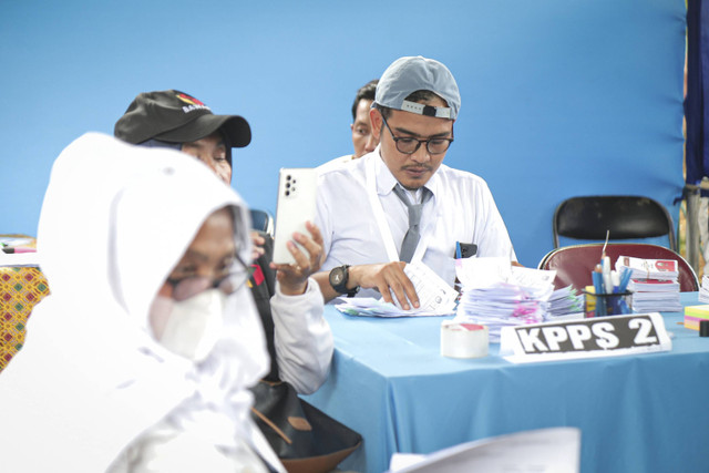 Anggota Kelompok Penyelenggara Pemungutan Suara (KPPS) berbusana seragam sekolah mempersiapkan TPS 005, Petamburan, Tanah Abang, Jakarta, Rabu (27/11/2024). Foto: Iqbal Firdaus/kumparan