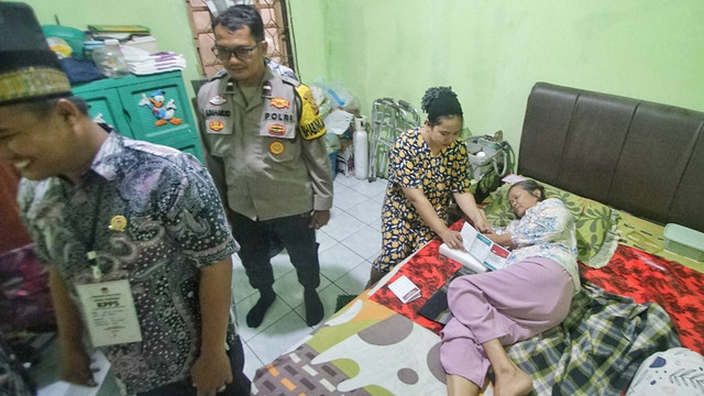 Anggota KPPS, Bawaslu, anggota Babinkamtibmas Polsek Plaju mendampingi warga yang melakukan pencoblosan di rumah dalam proses pilkada yang digelar di Palembang, Rabu (27/11) Foto: ary priyanto/urban id