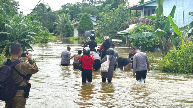 Polisi membantu warga melintasi banjir menggunakan rakit. Foto: Dok. Polres Sekadau