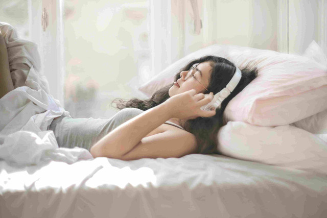 Foto oleh Andrea Piacquadio dari Pexels: https://www.pexels.com/id-id/foto/wanita-berbaring-di-tempat-tidur-sambil-mendengarkan-musik-3807536/