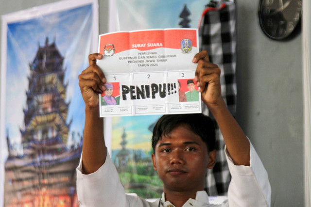 Petugas KPPS menunjukan surat suara pemilihan calon Gubernur dan Wakil Gubernur Jawa Timur saat penghitungan suara di TPS 01 Magersari, Sidoarjo, Jawa Timur, Rabu (27/11/2024). Foto: Umarul Faruq/ANTARA FOTO