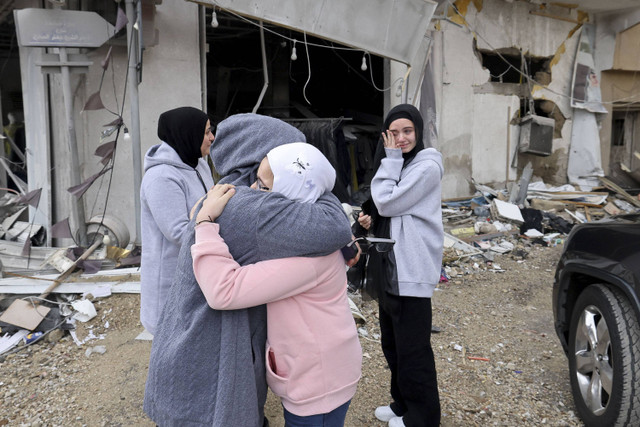 Para wanita saling menyapa ketika para pengungsi kembali ke rumah mereka di selatan Lebanon setelah gencatan senjata antara Israel dan Hizbullah diberlakukan, Rabu (27/11/2024). Foto: Anwar Amro/AFP