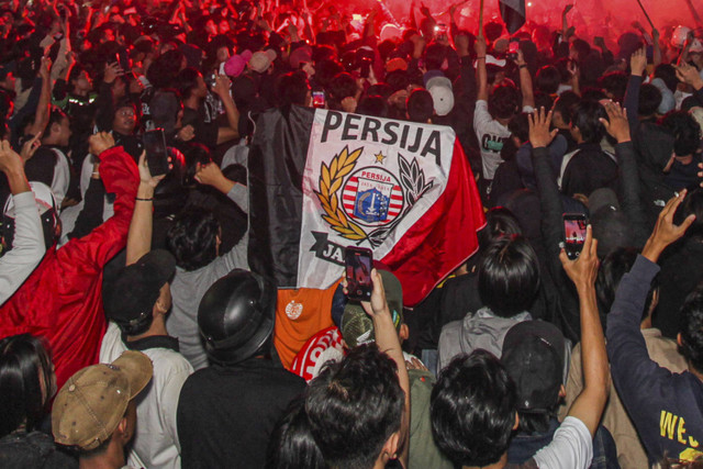 Massa pendukung klub sepak bola Persija Jakarta yang tergabung dalam The Jak Mania memadati kawasan Bundaran Hotel Indonesia (HI) untuk merayakan HUT yang ke-96 kesebelasan kesayangan mereka di Jakarta, Kamis (28/11/2024) dini hari. Foto: Zaky Fahreziansyah/ANTARA FOTO