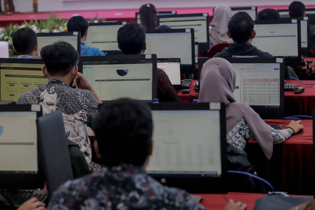 Petugas terlihat sibuk saat bertugas di ruang monitoring Sirekap di lantai 2 Kantor KPU Pusat, Jakarta, Sabtu (29/11/2024). Foto: Jamal Ramadhan/kumparan